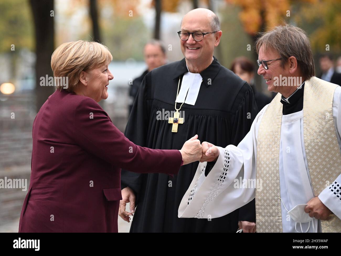 Berlin, Germany. 26th Oct, 2021. The Plenipotentiary of the Council of the Evangelical Church in Germany (EKD), Martin Dutzmann (m), and the Head of the Catholic Office in Berlin, Prelate Karl Jüsten (r), receive Federal Chancellor Angela Merkel (CDU) for the ecumenical service in the St. Mary's Church in Berlin before the constituent session of the new Bundestag. Credit: Britta Pedersen/dpa/Alamy Live News Stock Photo
