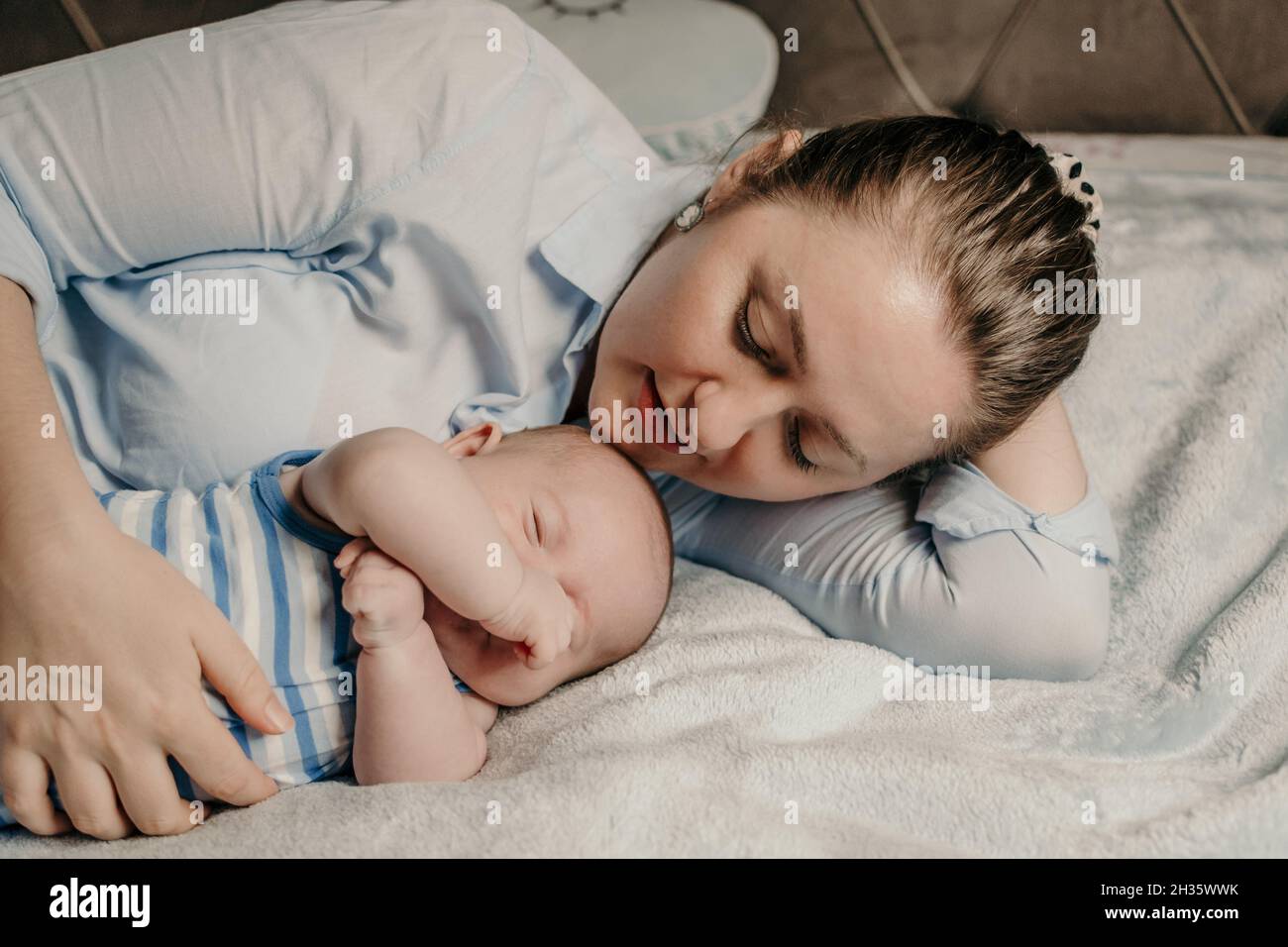 Mother and newborn baby boy cuddling in bed Stock Photo Alamy