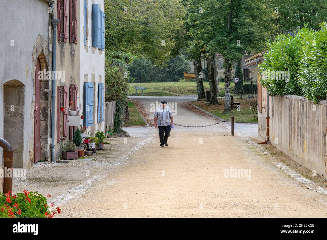 A priest walking down the street of the small village Labastide d'Armagnac, southern France Stock Photo