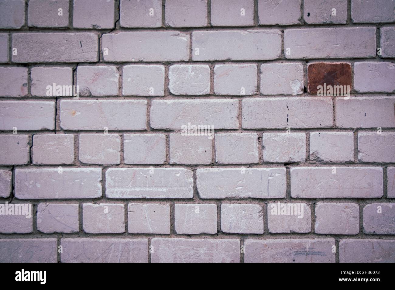 Painted in grey white colors old vintage empty brick wall background with copy space. Rustic cemented house stonewall texture with grunge surface. Shabby Building Facade With Damaged Plaster Stock Photo
