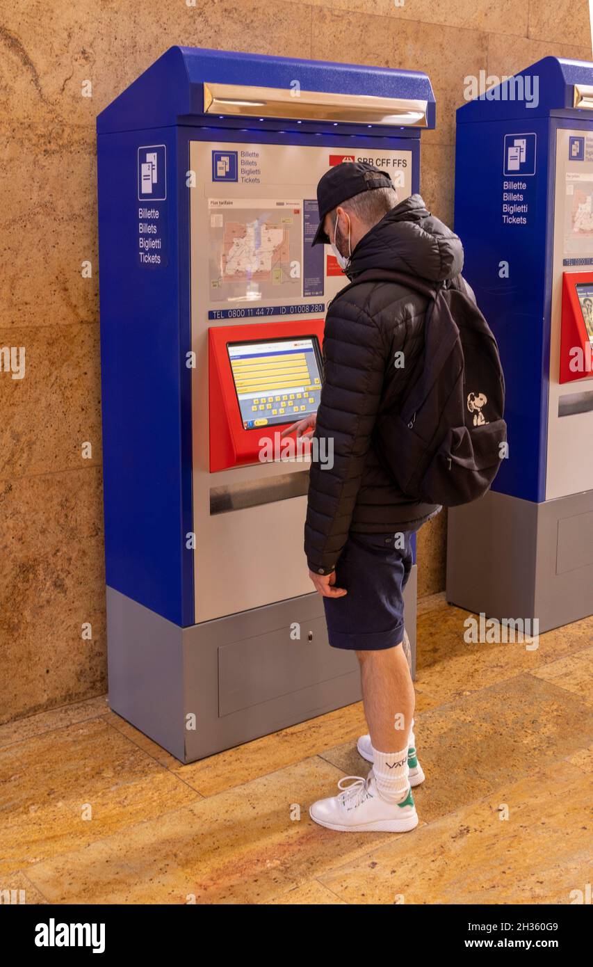 man buying train ticket from machine, Geneva-Cornavin railway station, Geneva, Switzerland Stock Photo