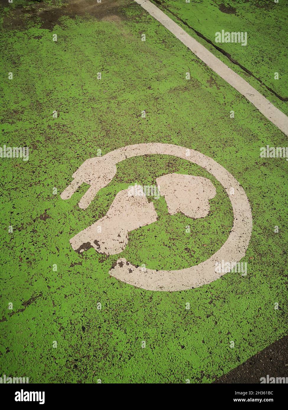 Painted sign for electric vehicle parking on the ground. Stock Photo