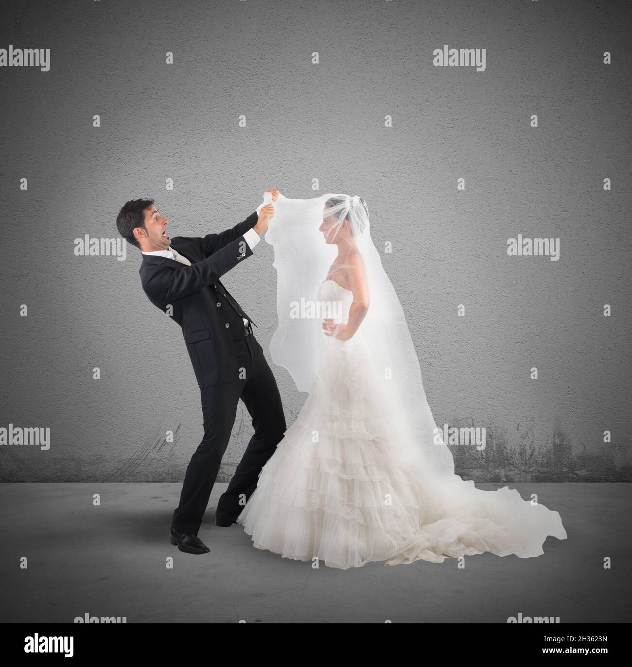 Amazed husband lifts the veil of wife Stock Photo