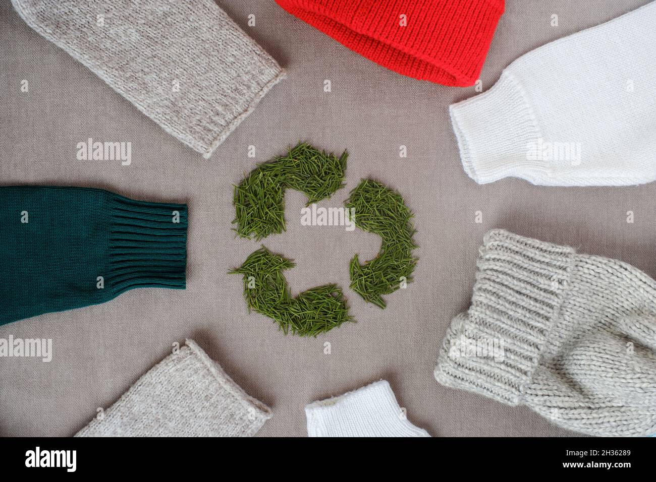 Recycling sign with Christmas tree needles. Winter recycling clothes. Top view or flat lay. Stock Photo
