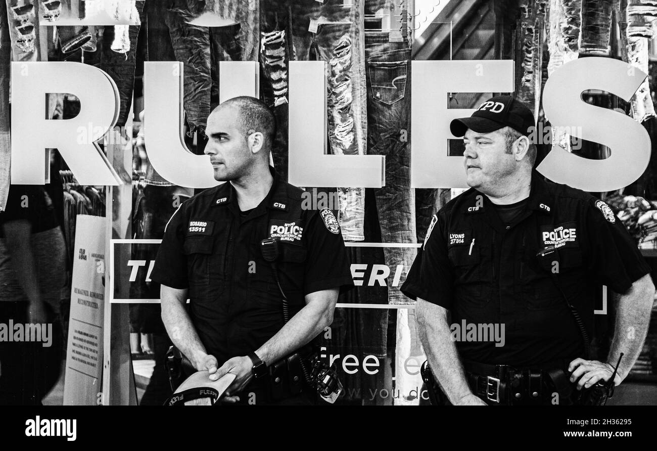 Black and White image of two New York policemen with the coincidental word  RULES behind them on a store window Stock Photo