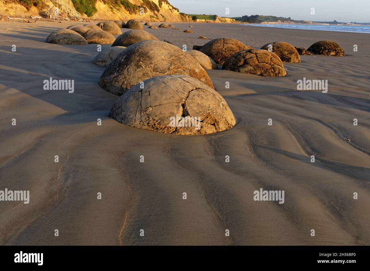 A line of Moeraki Boulders sit on the beach in New Zealand's South Island. Stock Photo