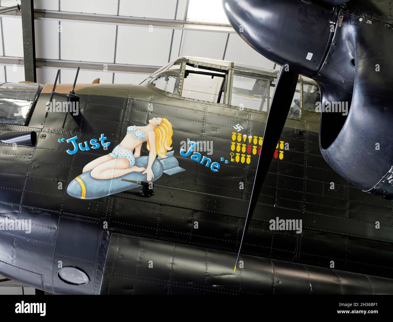 Nose art on Avro Lancaster NX611 'Just Jane' ujnder restoration at the Lincolnshire Aviation Heritage Centre, East Kirkby Airfield near Spilsby. Stock Photo