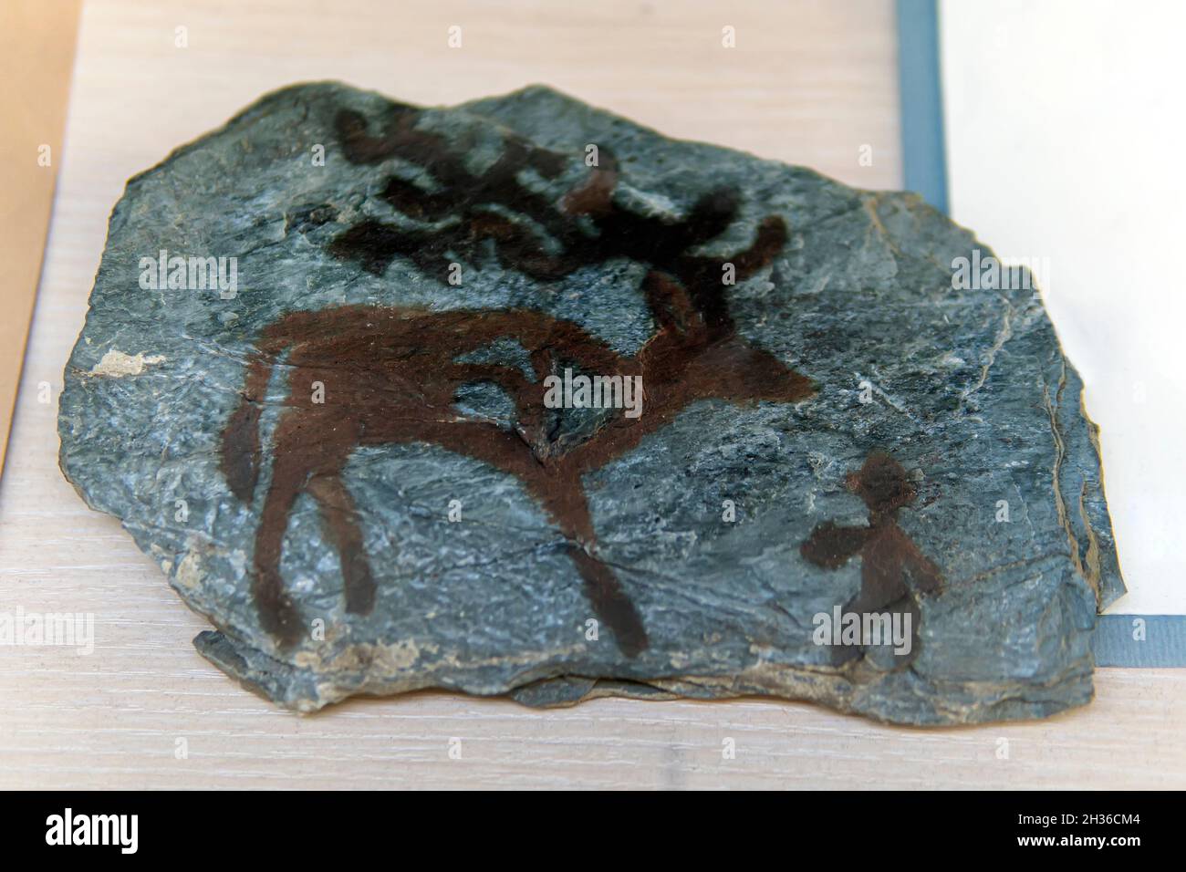 Famous prehistoric rock paintings. Drawings of ancient people on a blue stone. Stock Photo