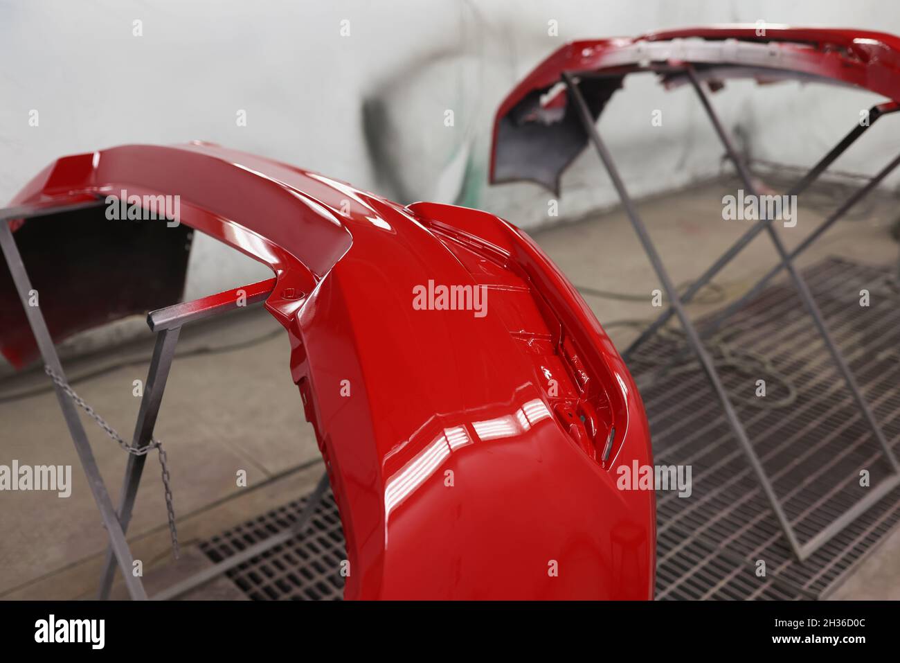 Painted red bumpers to drying in workshop closeup. Auto detailing concept Stock Photo
