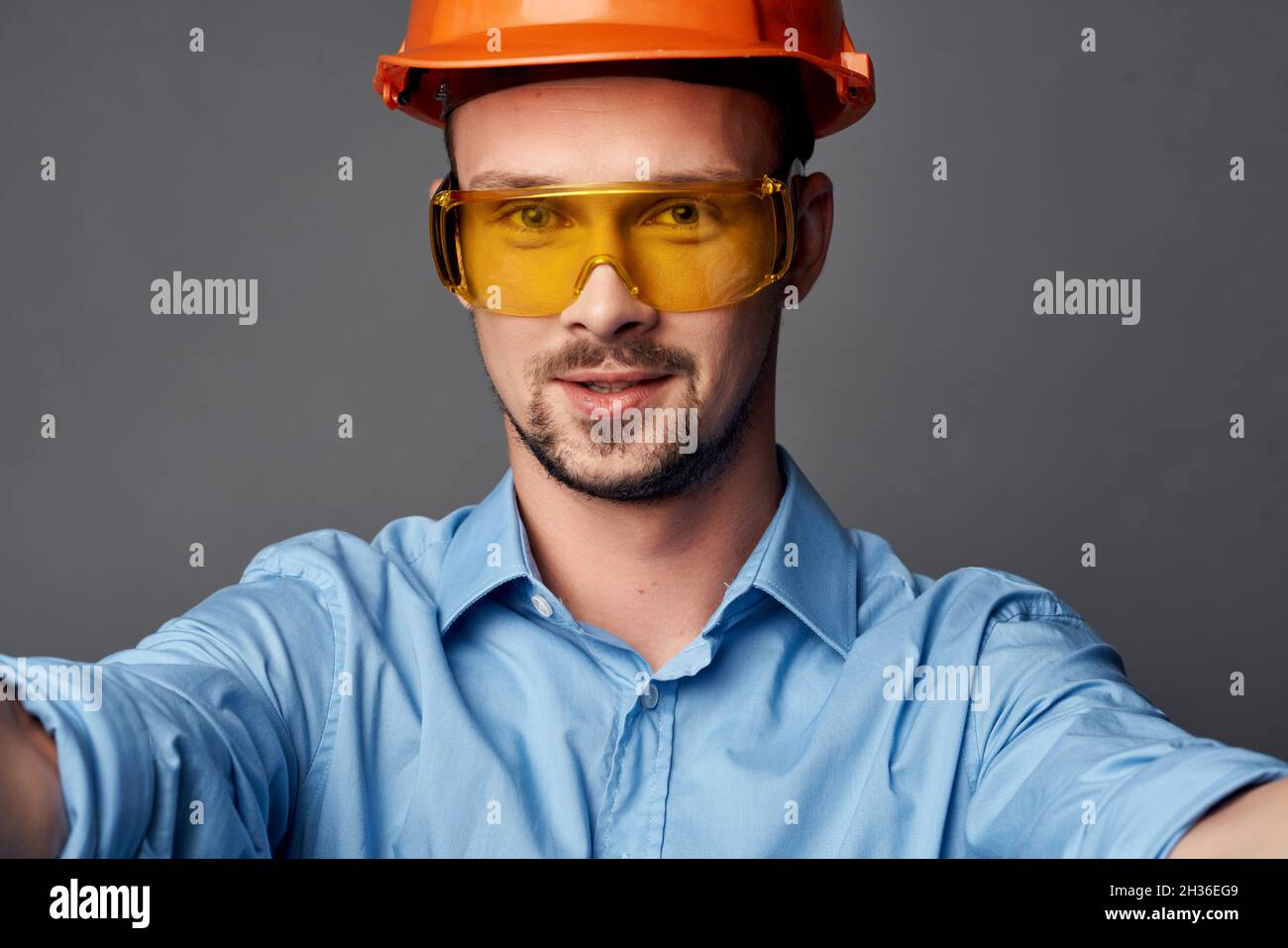 man in orange hard hat blue shirt construction design Stock Photo