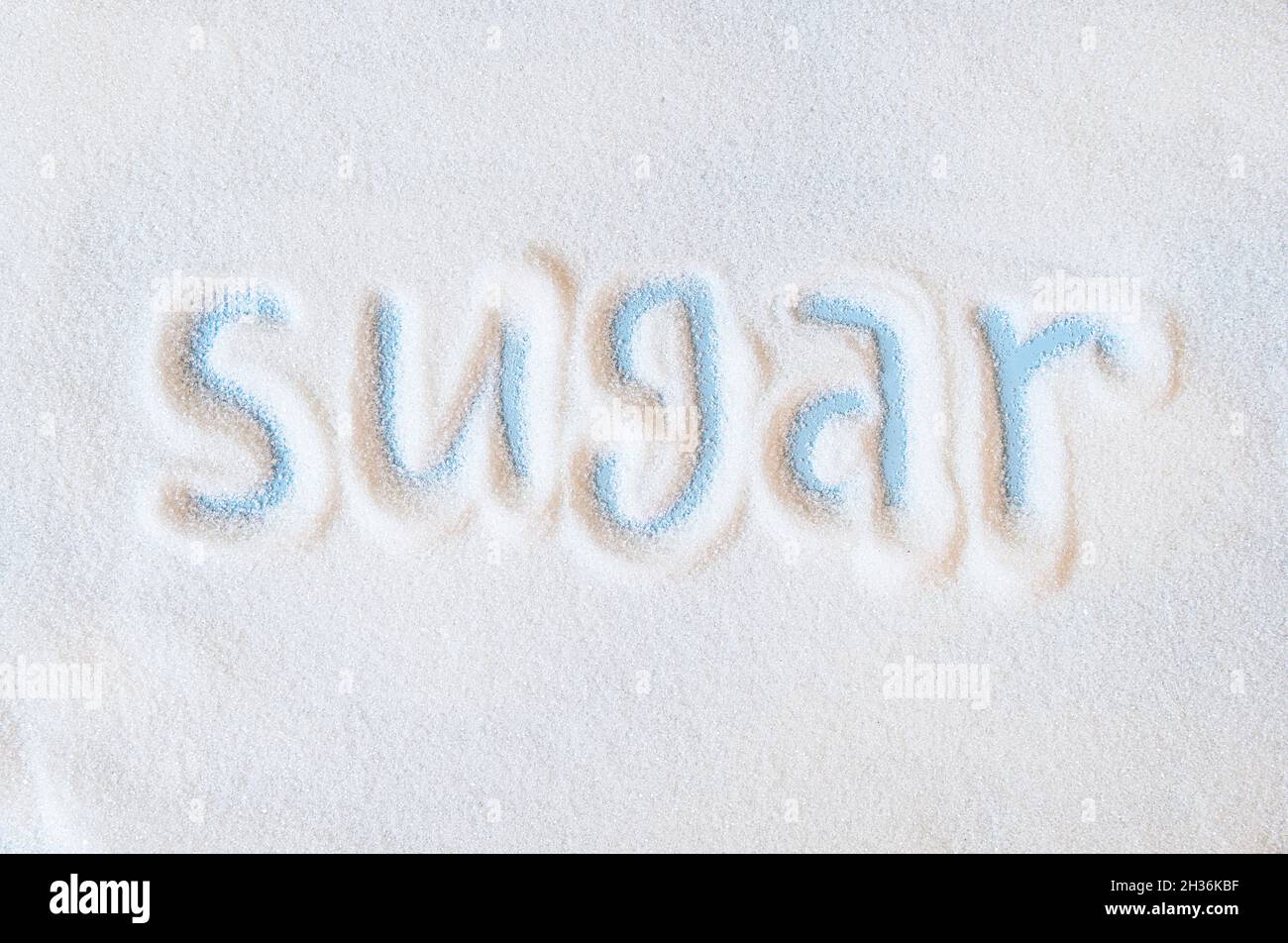 Word sugar hand lettering on placer of refined white sugar. Beet sugar ...