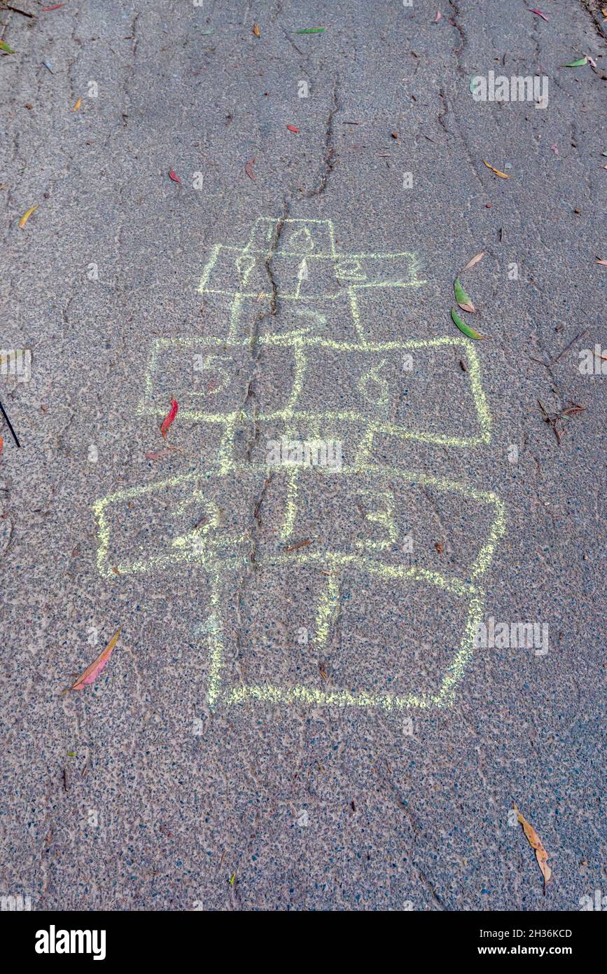 Simple child like hopscotch squares drawn in chalk on an asphalt roiad surface in Sydney, Australia Stock Photo