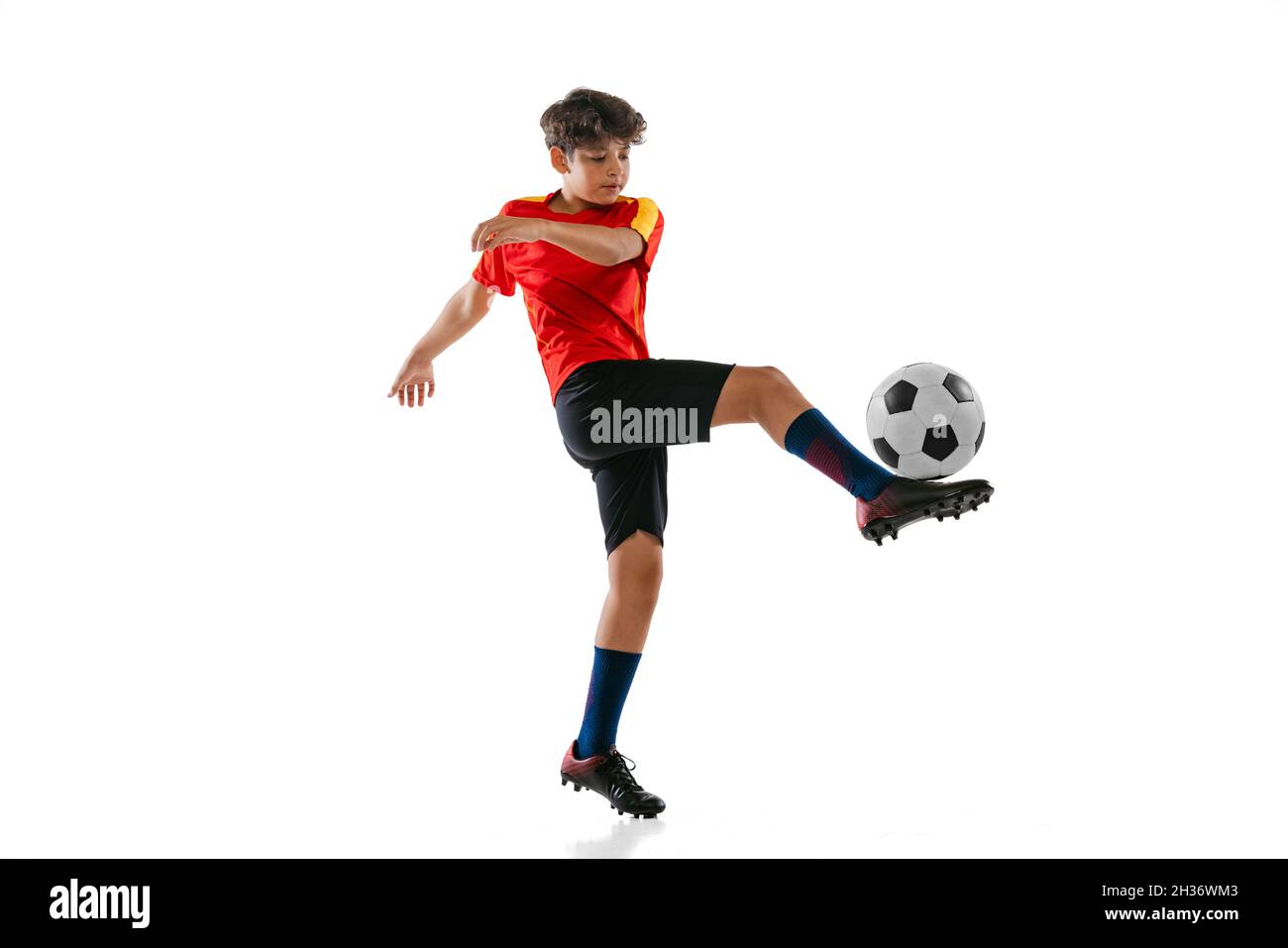 Fulllength portrait of boy, male soccer football player training