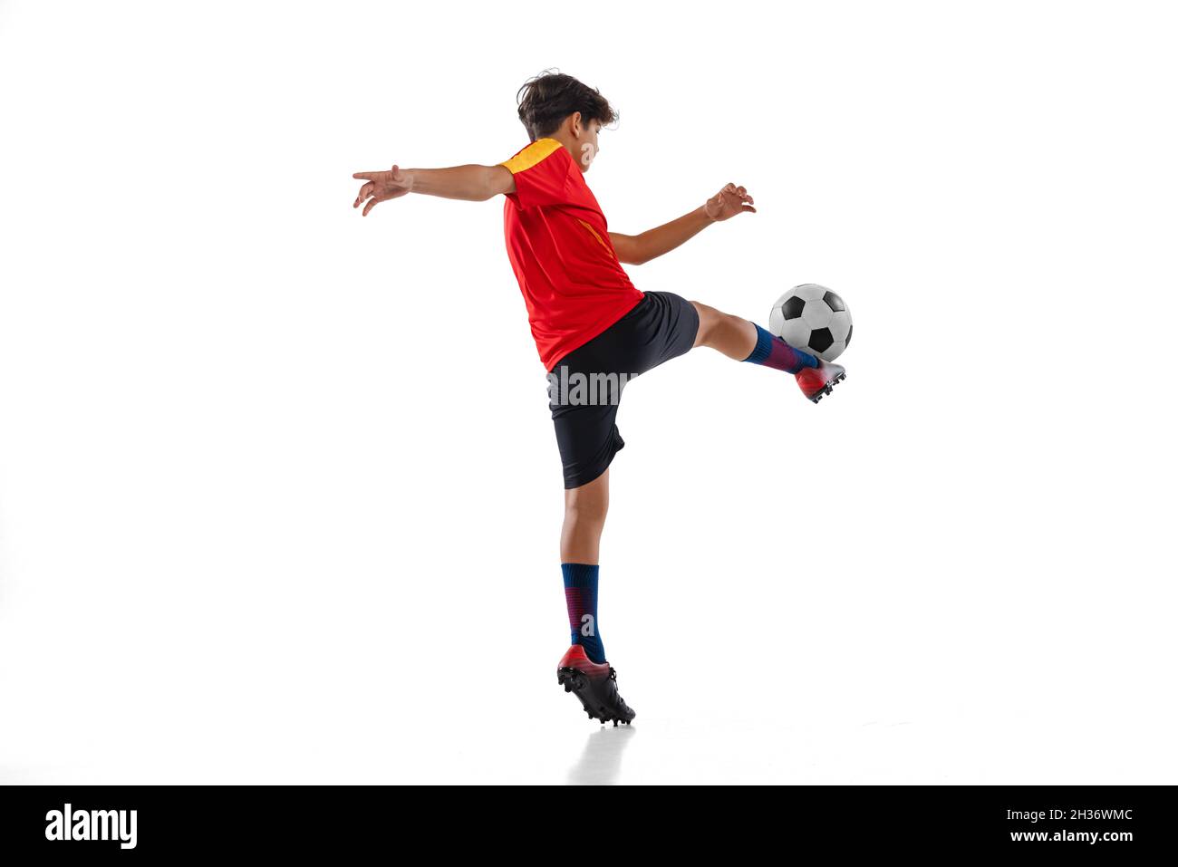 Fulllength portrait of boy, male soccer football player training