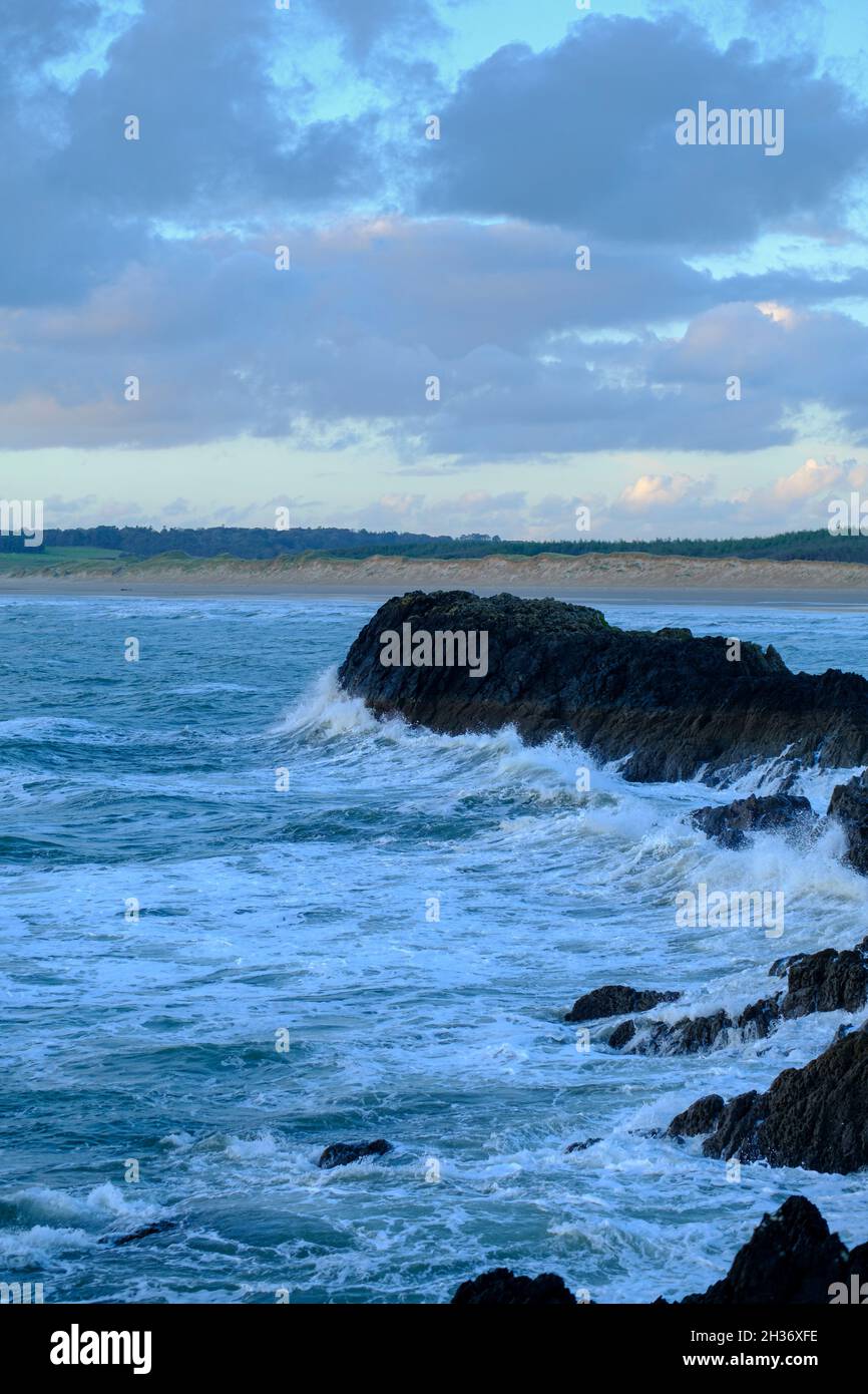 The sea crashing into rocks on Malltraeth beach on Angelsey in North Wales, UK Stock Photo