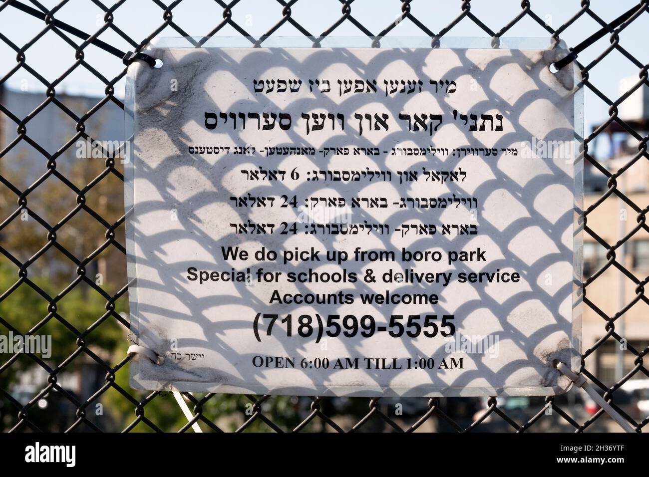A bilingual advertisement in Yiddish and English, for a car & van service primarily used by orthodox Jews. On Lee Ave in Williamsburg, Brooklyn, NYC. Stock Photo