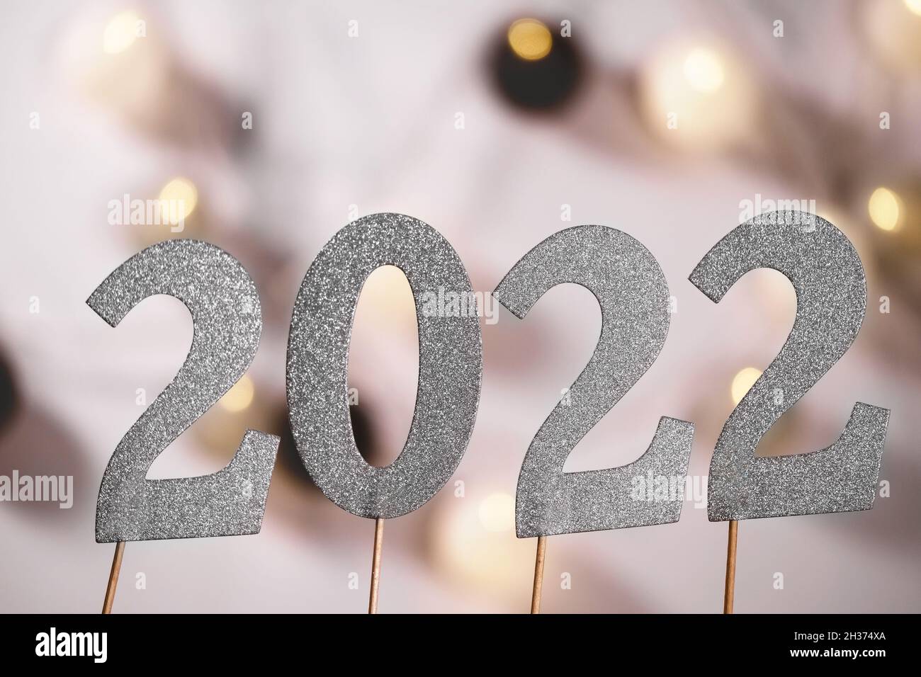 2022 number in sparkling silver over lights bokeh celebrating New Year Party Celebration Stock Photo