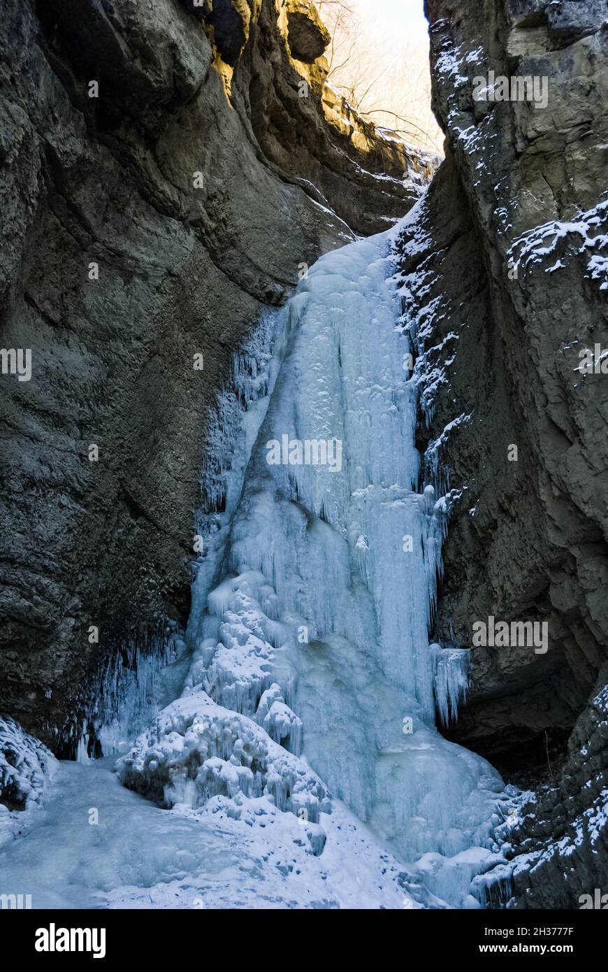 Frozen waterfall with huge beautiful icicles hanging from the rocks ...