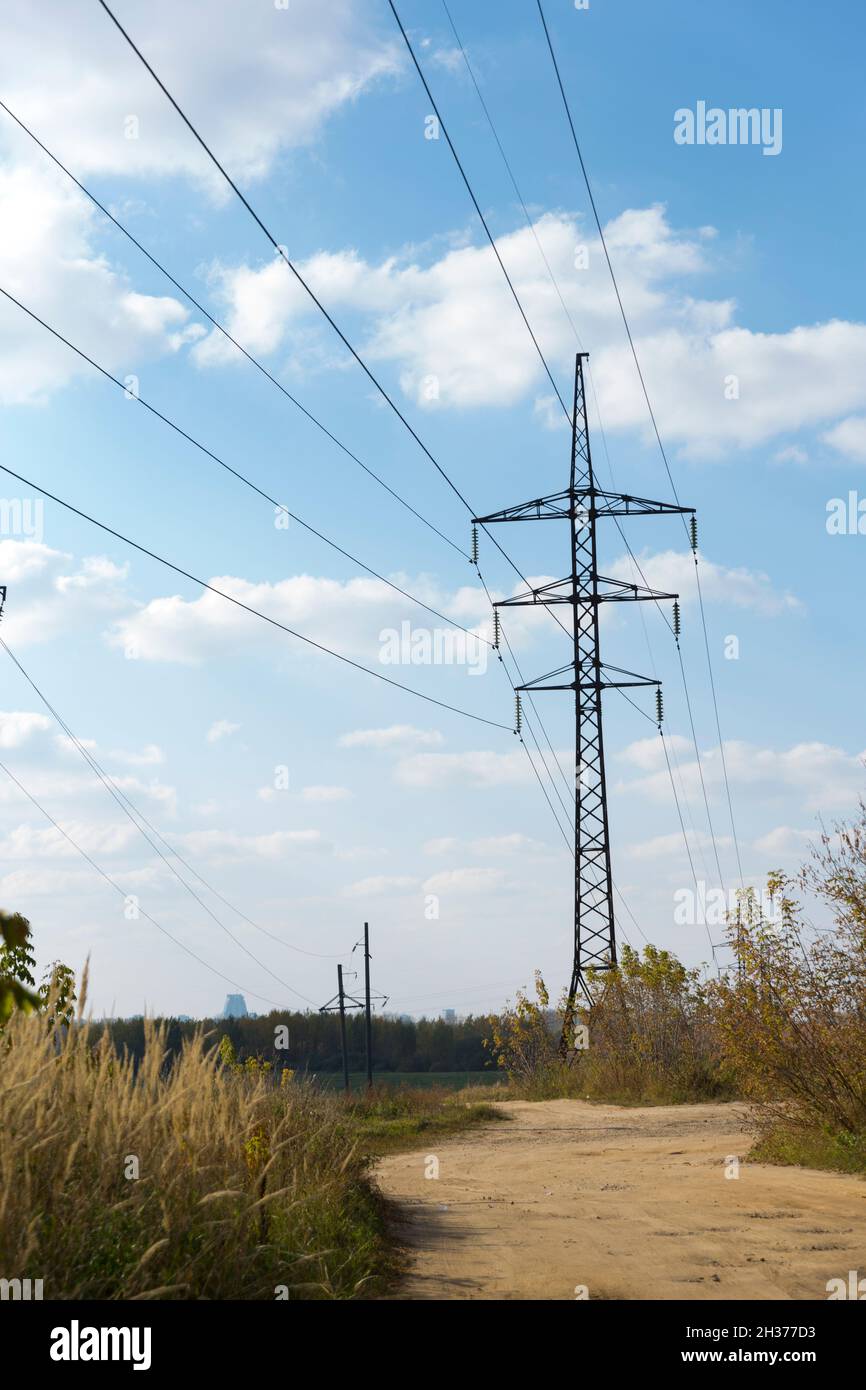 Pylons and wires of high-voltage electricity in a green field and ...