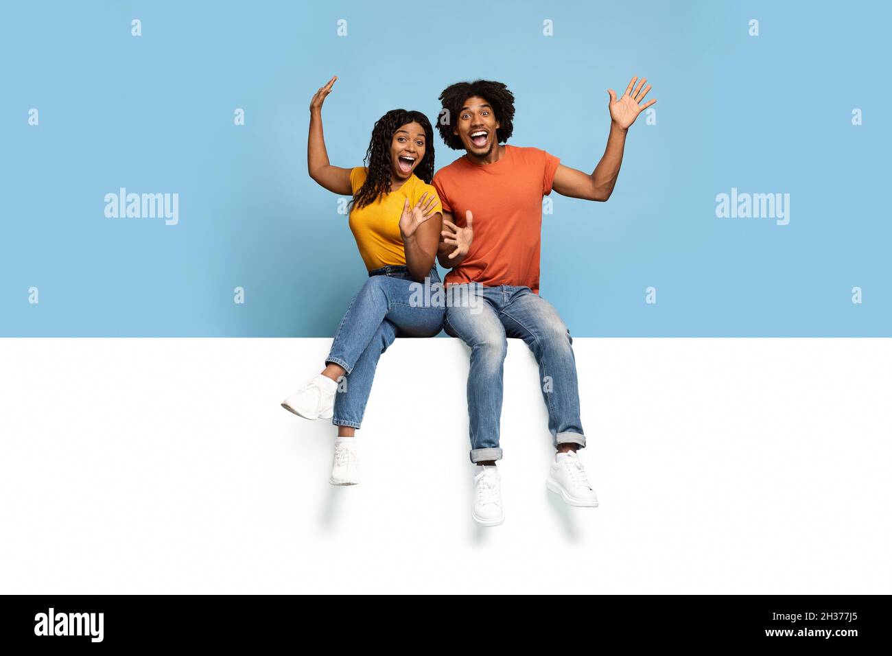 Excited black couple sitting hi-res stock photography and images - Alamy