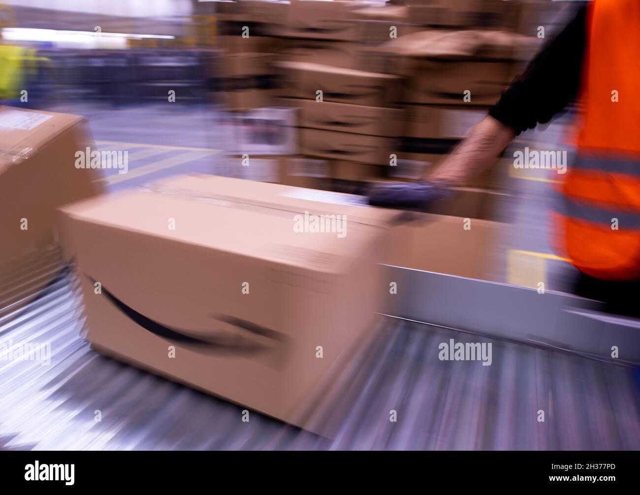 13 October 2021, Mecklenburg-Western Pomerania, Neubrandenburg: Employees  sort parcels from online retailer Amazon at the new distribution center.  The retailer's second distribution center in Mecklenburg-Western Pomerania  is officially opened today ...