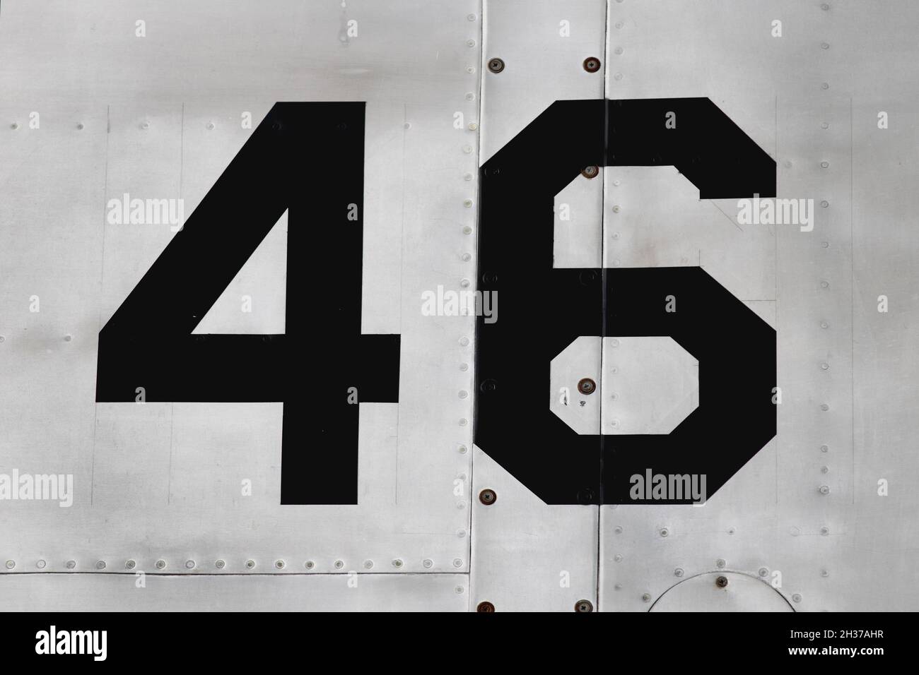 Number 46 on the side of the silver metallic fuselage of an aircraft Stock Photo