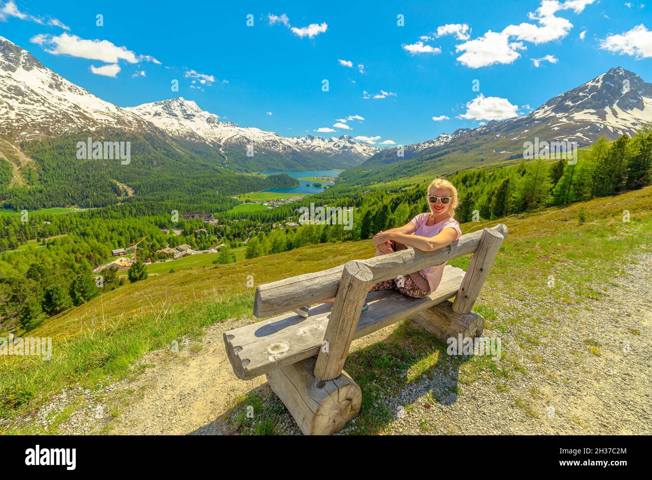 tourist girl relaxes on top of Piz Nair in Switzerland. Swiss cable car St. Moritz Bad-Signal in Corviglia of Piz Nair mountain of Albula alps. Lake Stock Photo