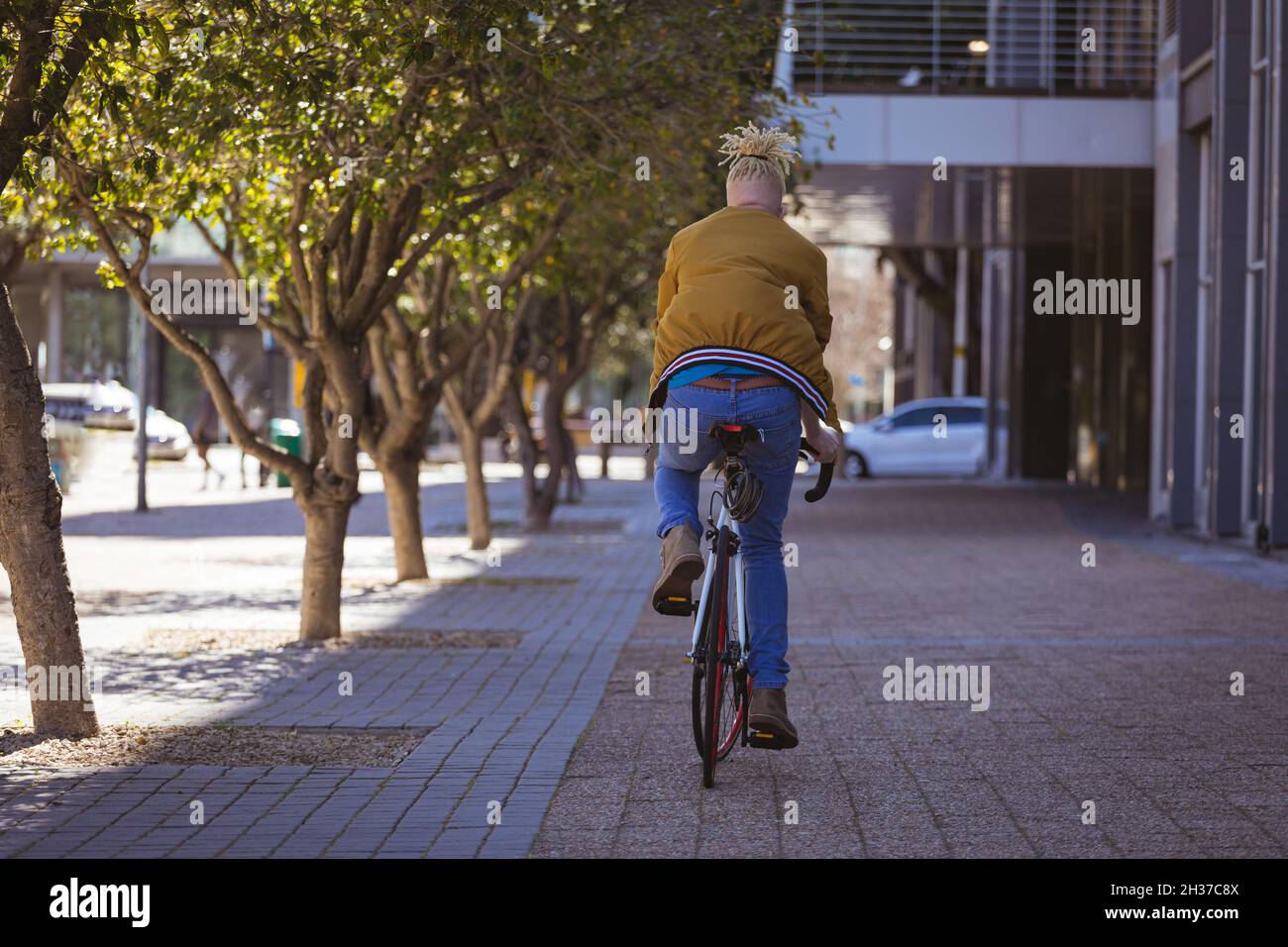 Albino african american man with dreadlocks riding bike Stock Photo