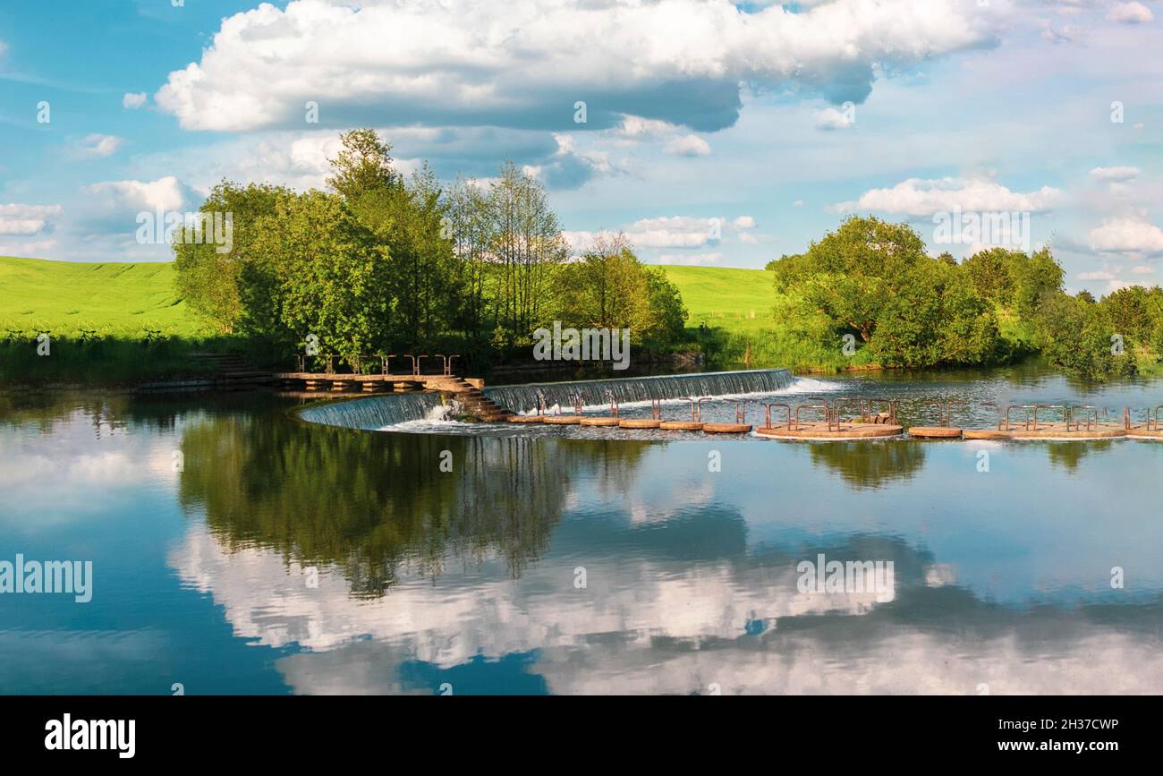 reflection of a bright blue sky with white clouds in the water ...