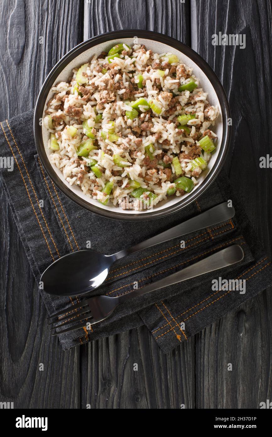 Dirty rice is a classic Cajun dish that is typically made with chicken livers and ground meat close-up in a plate on the table. Vertical top view from Stock Photo