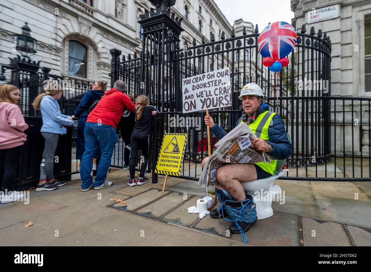 London, UK.  26 October 2021.  Steve Bray, well known anti-Brexit campaigner, stages a protest outside Downing Street whilst seated on a toilet, bringing attention to the impact of untreated sewage in the seas around the UK and on the environment.  His protest comes ahead of the upcoming UN Climate Change Conference of the Parties (COP26) taking place in Glasgow.  Credit: Stephen Chung / Alamy Live News Stock Photo