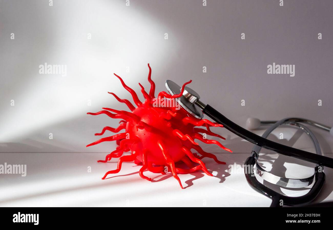 Stethoscope with a red ball similar to a virus on a white background. Stock Photo