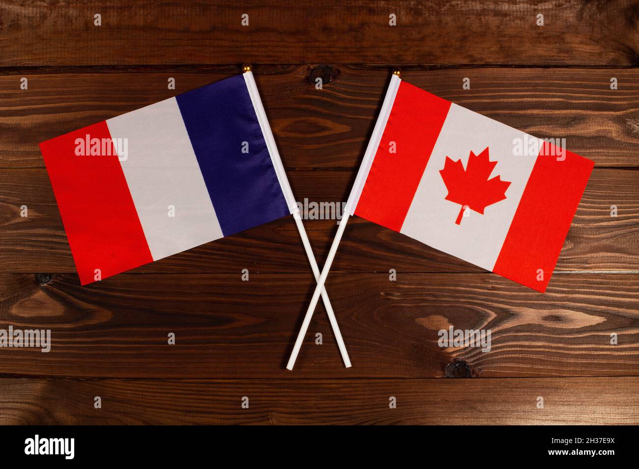 Flag of France and flag of Canada crossed with each other. France vs Canada Stock Photo