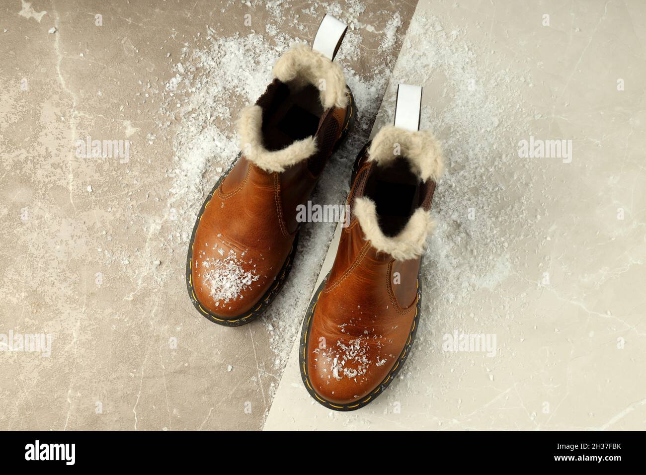 Boots with snow on two tone background. Stock Photo
