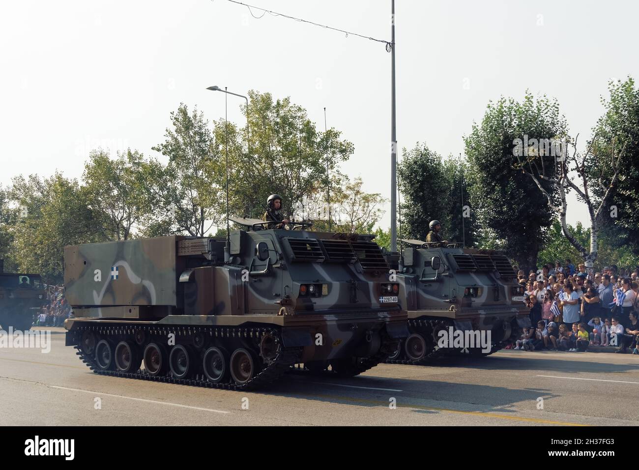 Thessaloniki, Greece - October 28 2019: Oxi Day Greek Army tanks parade. Hellenic military march during national day celebration, with crowd cheering holding flags. Stock Photo