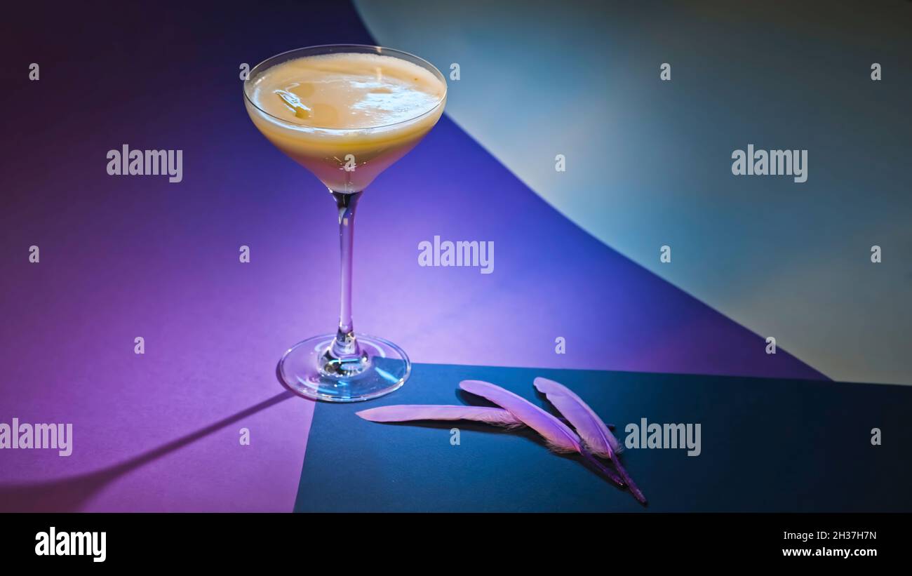 Performance with alcoholic drink on purple background. Stock footage. Alcoholic cocktail on elegant background. Beautiful decoration of alcoholic Stock Photo