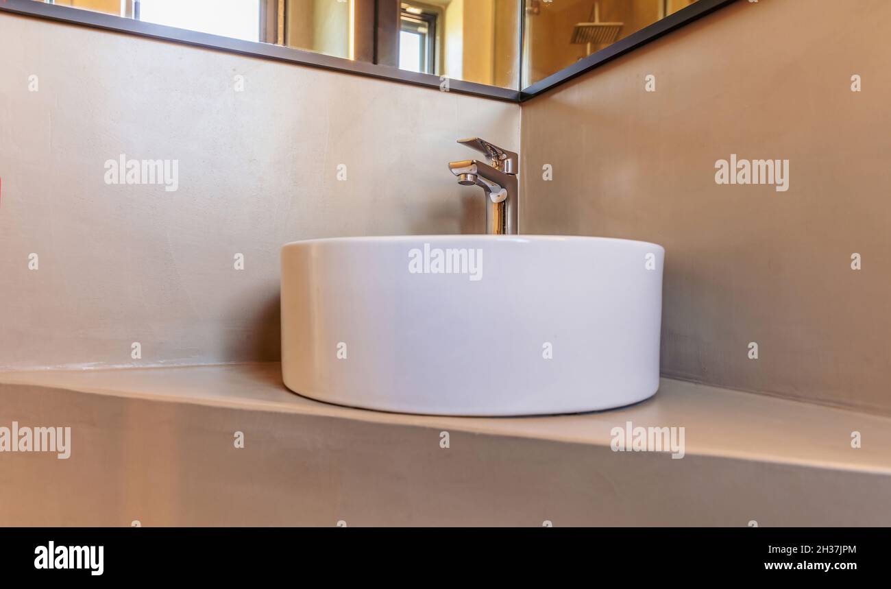 Bathroom sink basin and faucet, interior detail. Chrome mixer tap and round porcelain washbasin, grey wall background. Modern minimal design. 3d illus Stock Photo