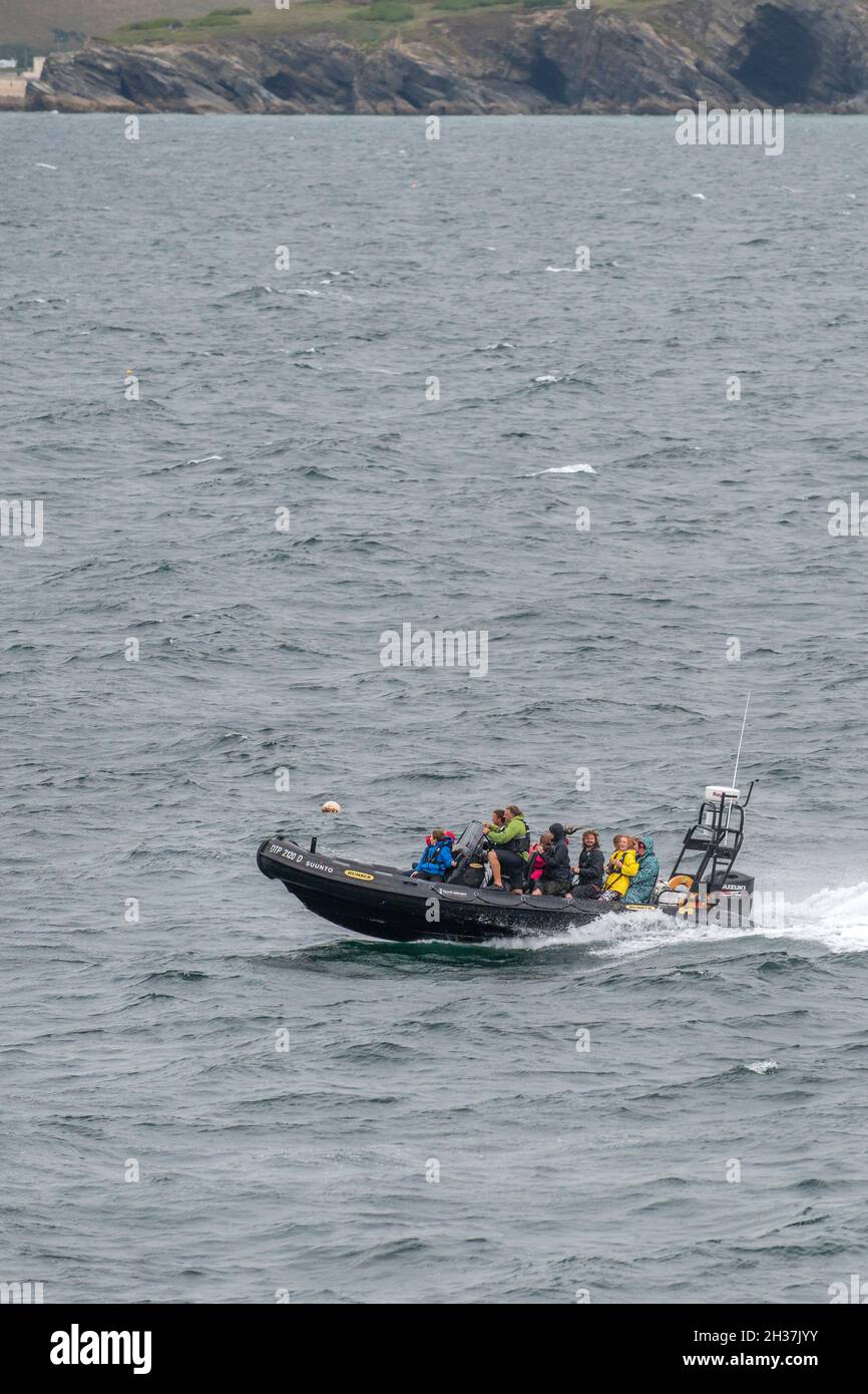A Rigid Inflatable Boat RIB full of holidaymakers passengers at full speed in choppy sea in Newquay Bay in Cornwall. Stock Photo