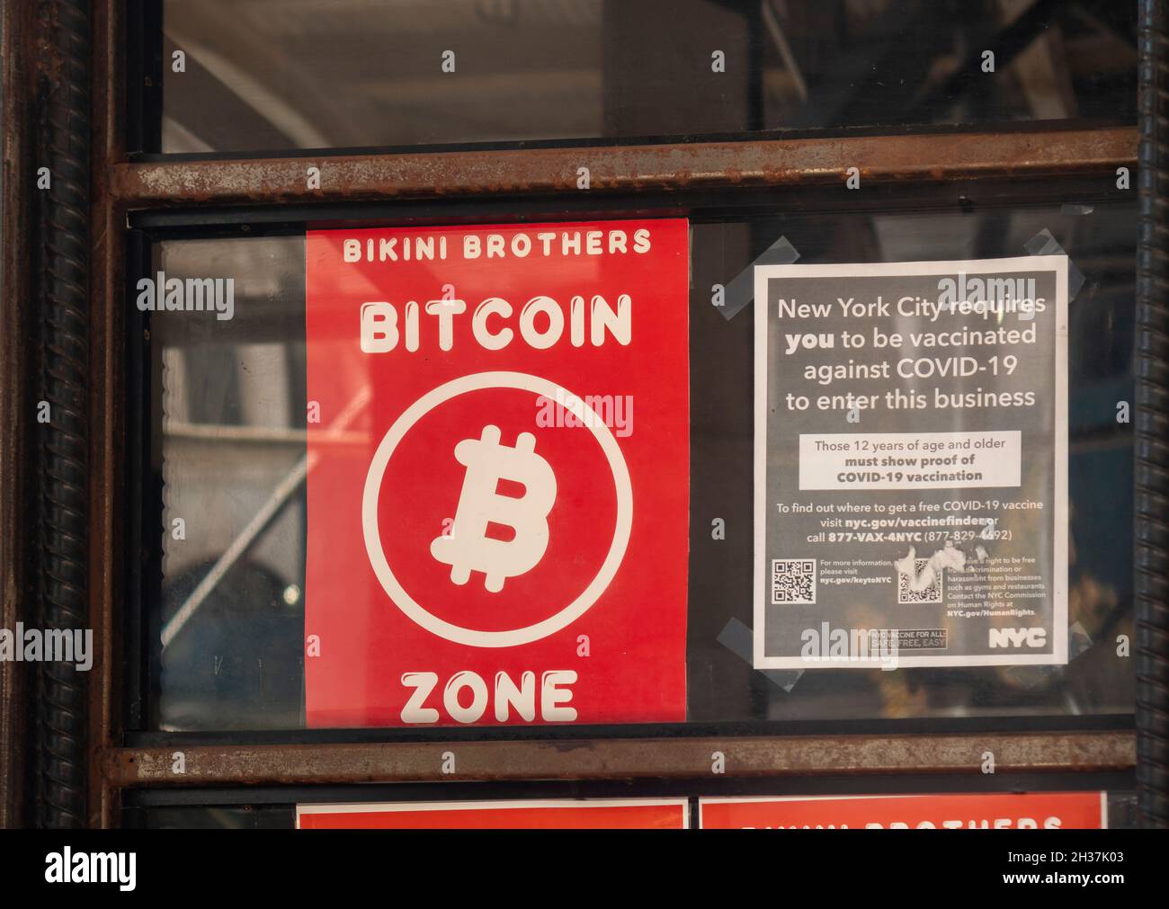 A sign promoting Bitcoin is displayed in the window of a bar in New York on Thursday, October 7, 2021.  (© Richard B. Levine) Stock Photo