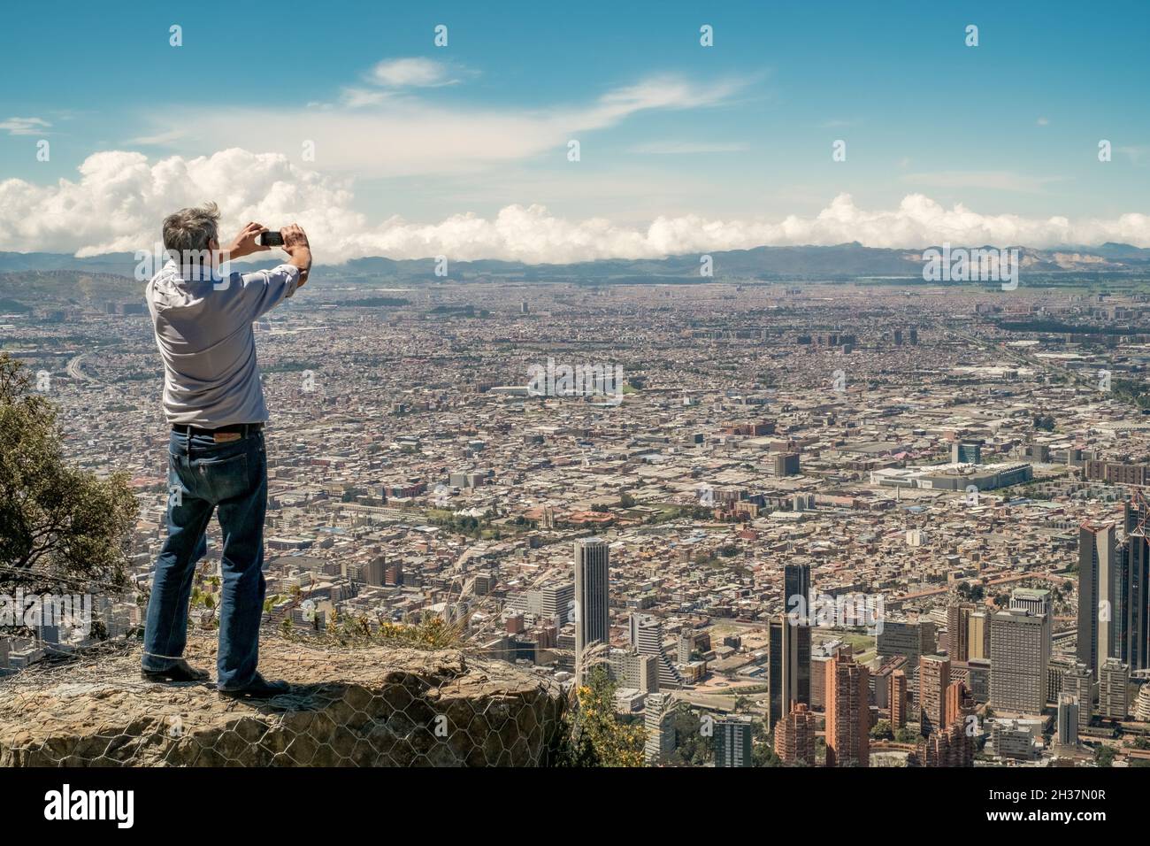 Bogotá, Colombia. A tourist take pictures of the city with smartphone along the pathway to Monserrate. Stock Photo