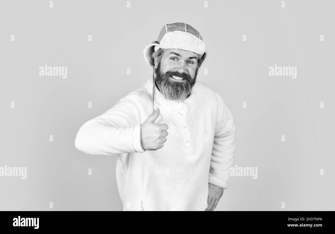 mature man posing with funny outfit. man beard in winter hat. portrait of trendy guy wearing hat. Male winter style. Modern winter earflap beanie hat Stock Photo