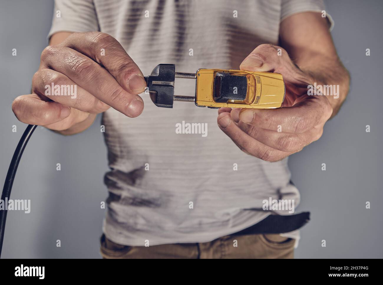 Man with toy car and electricity plug Stock Photo