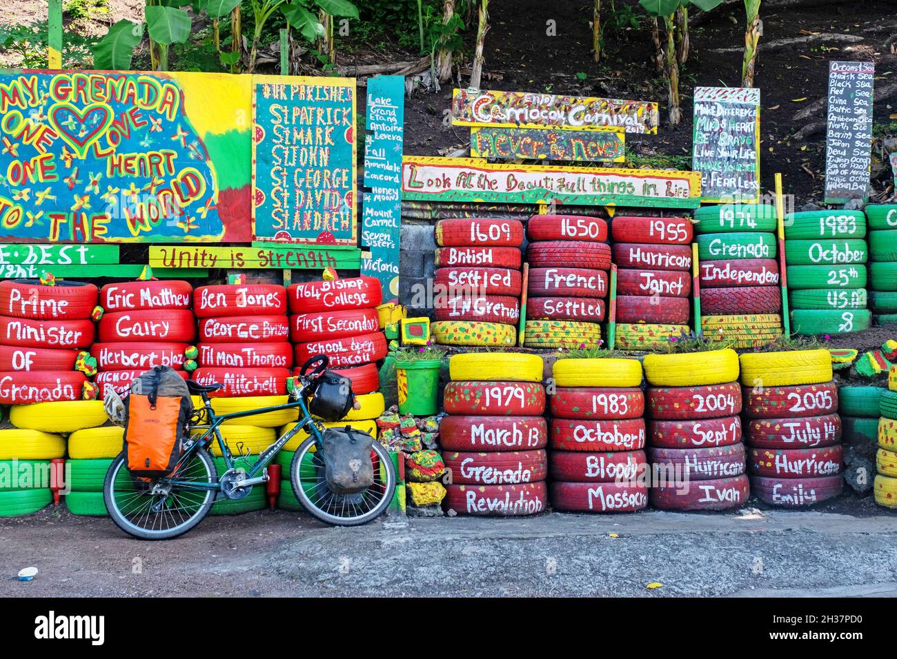 Wall of car tyres in the colours of Grenada on Happy Hill opposite Charlie's bar, Saint George on the west coast of the island of Grenada, Caribbean Stock Photo