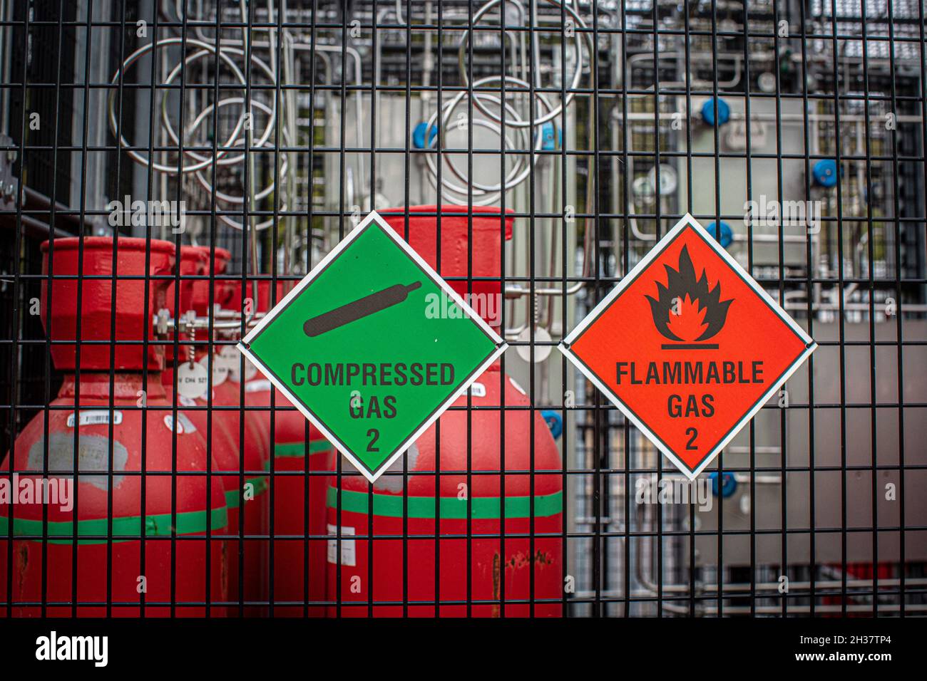 Gas bottles in storage yard. Various gaseous chemicals stored in steel bottles. Stock Photo