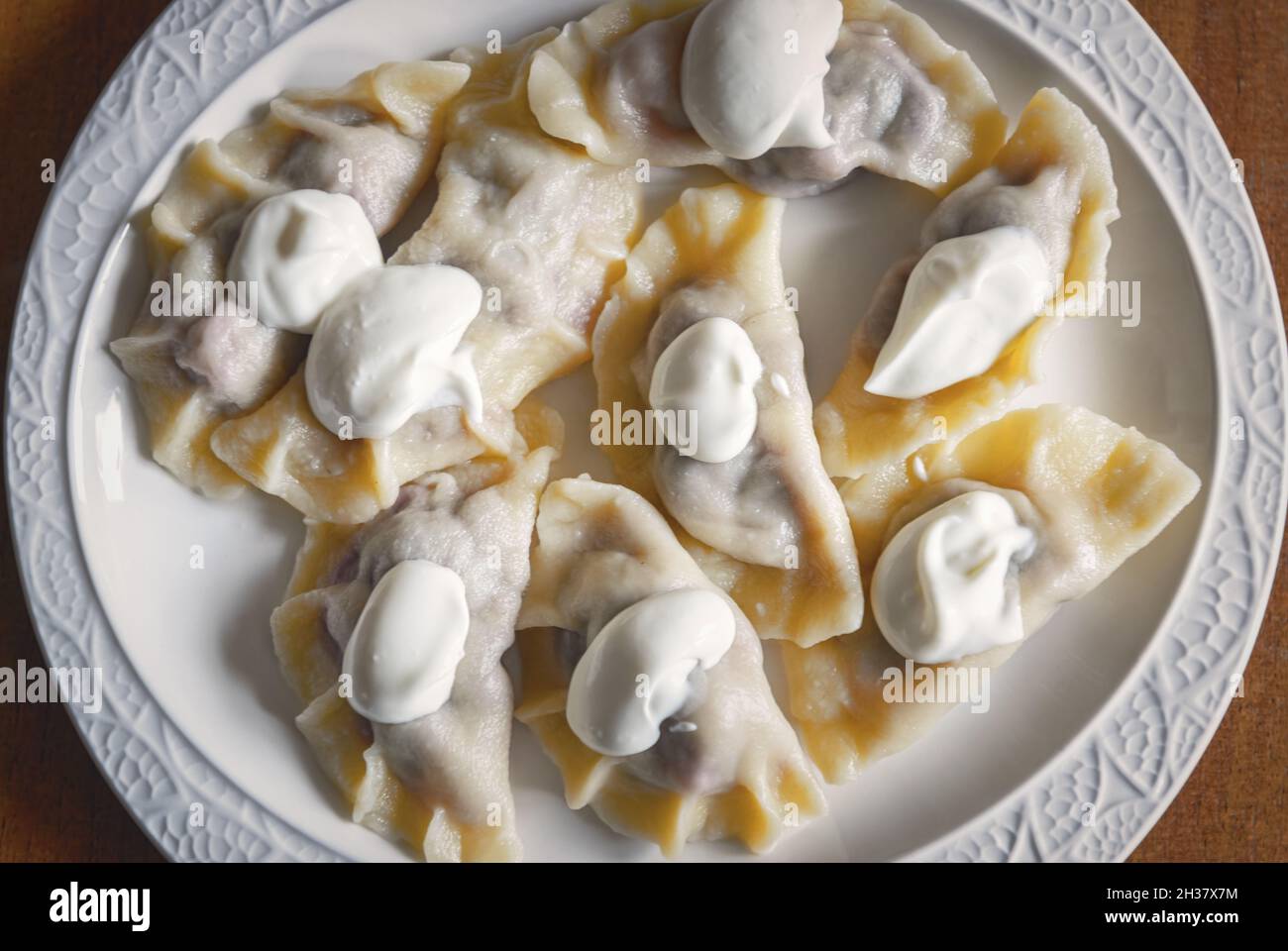 Fresh dumplings with cherry filling and cream on a plate Stock Photo