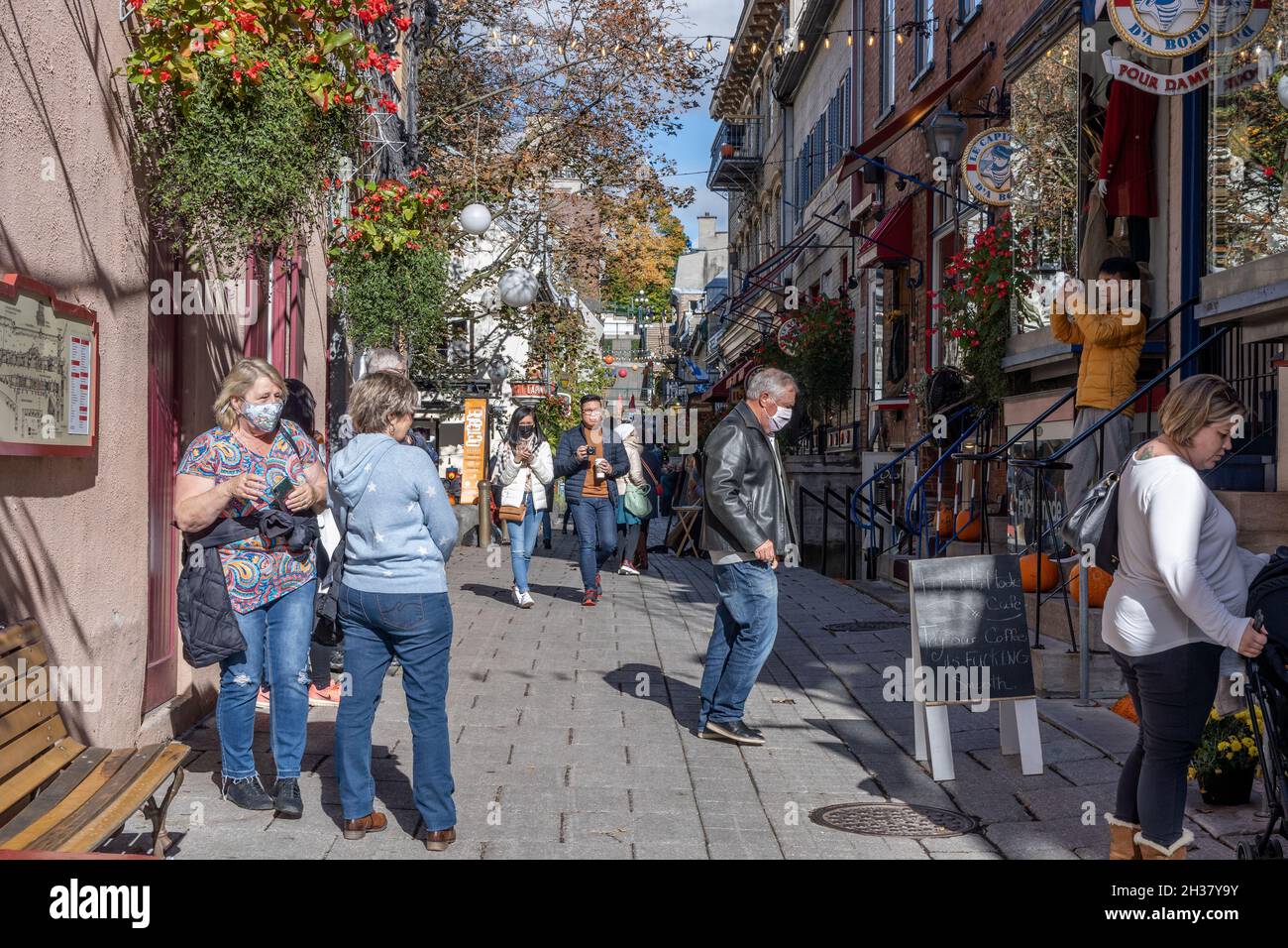 People walking on the Quartier du Petit Champlain street during covid-19 pandemic period. A small commercial zone in Quebec City. Stock Photo