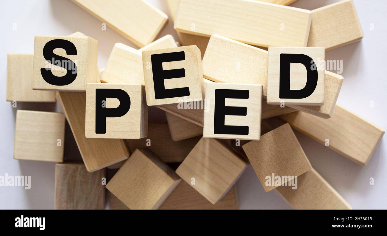 Speed, the text is written on wooden cubes, blocks. Many cubes lie on a white background Stock Photo