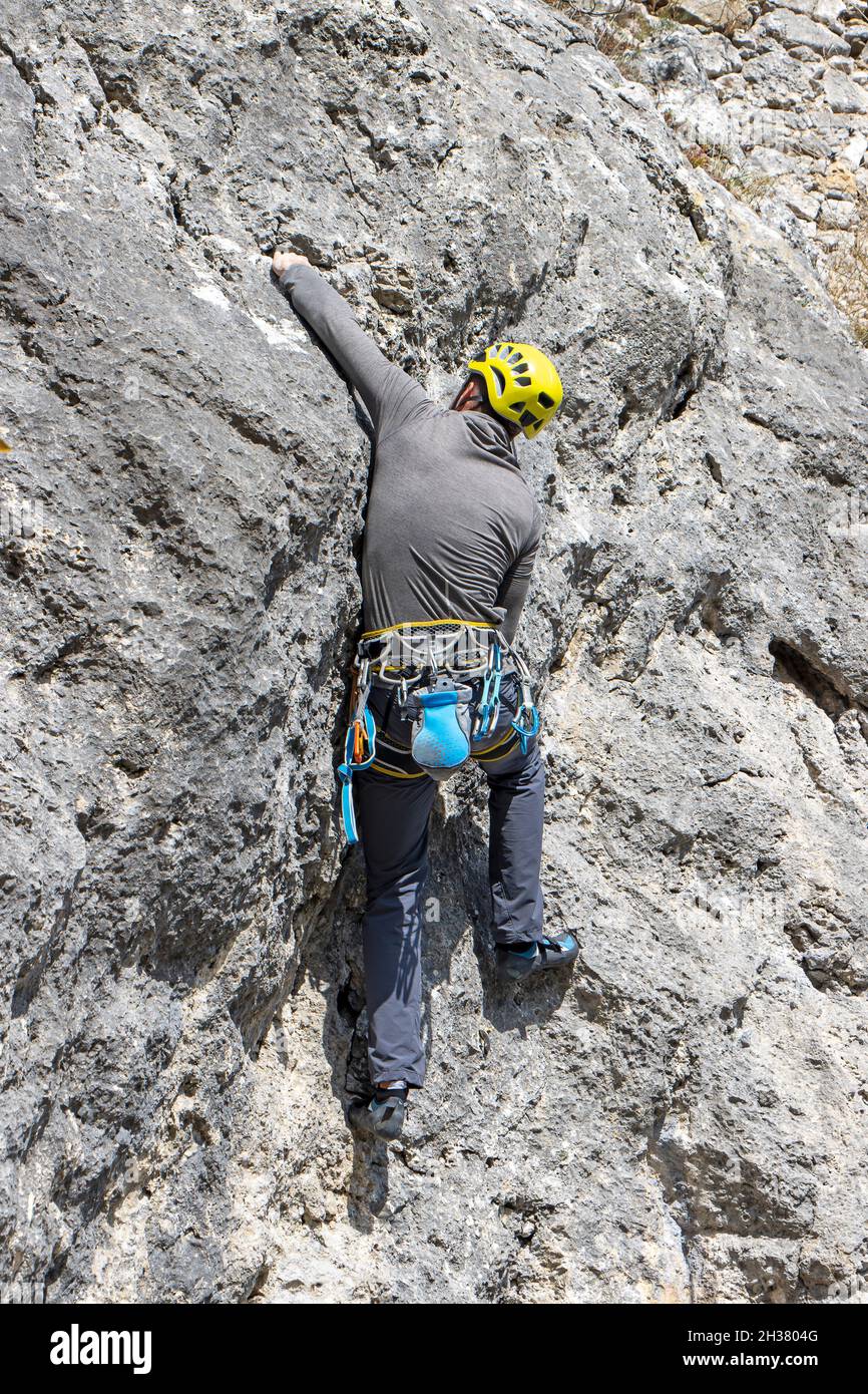 Young sports man climbing natural high rocky wall on Kalnik, Croatia Stock Photo
