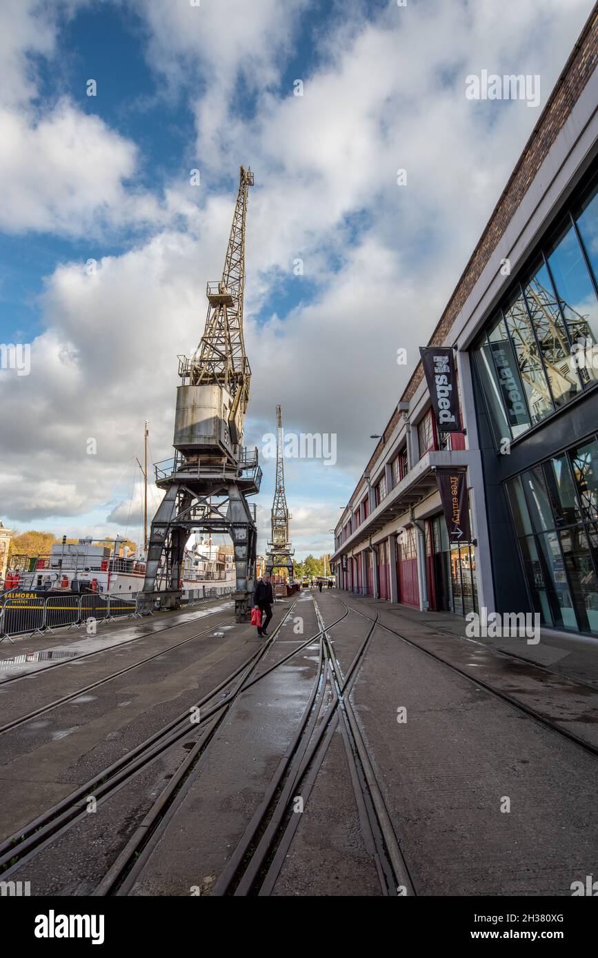 Wide angle view of tramlines and cranes at Bristol docks with the M Shed building on the right hand side Stock Photo
