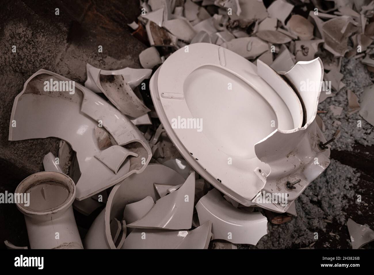 Broken toilet in a garbage container Stock Photo